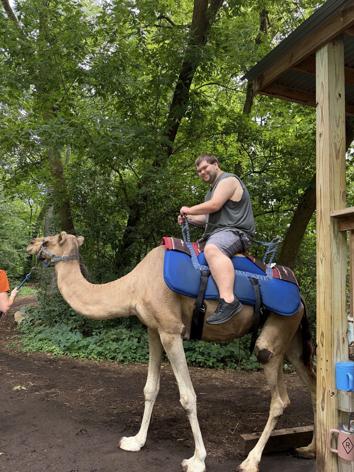A resident smiling while riding a camel
